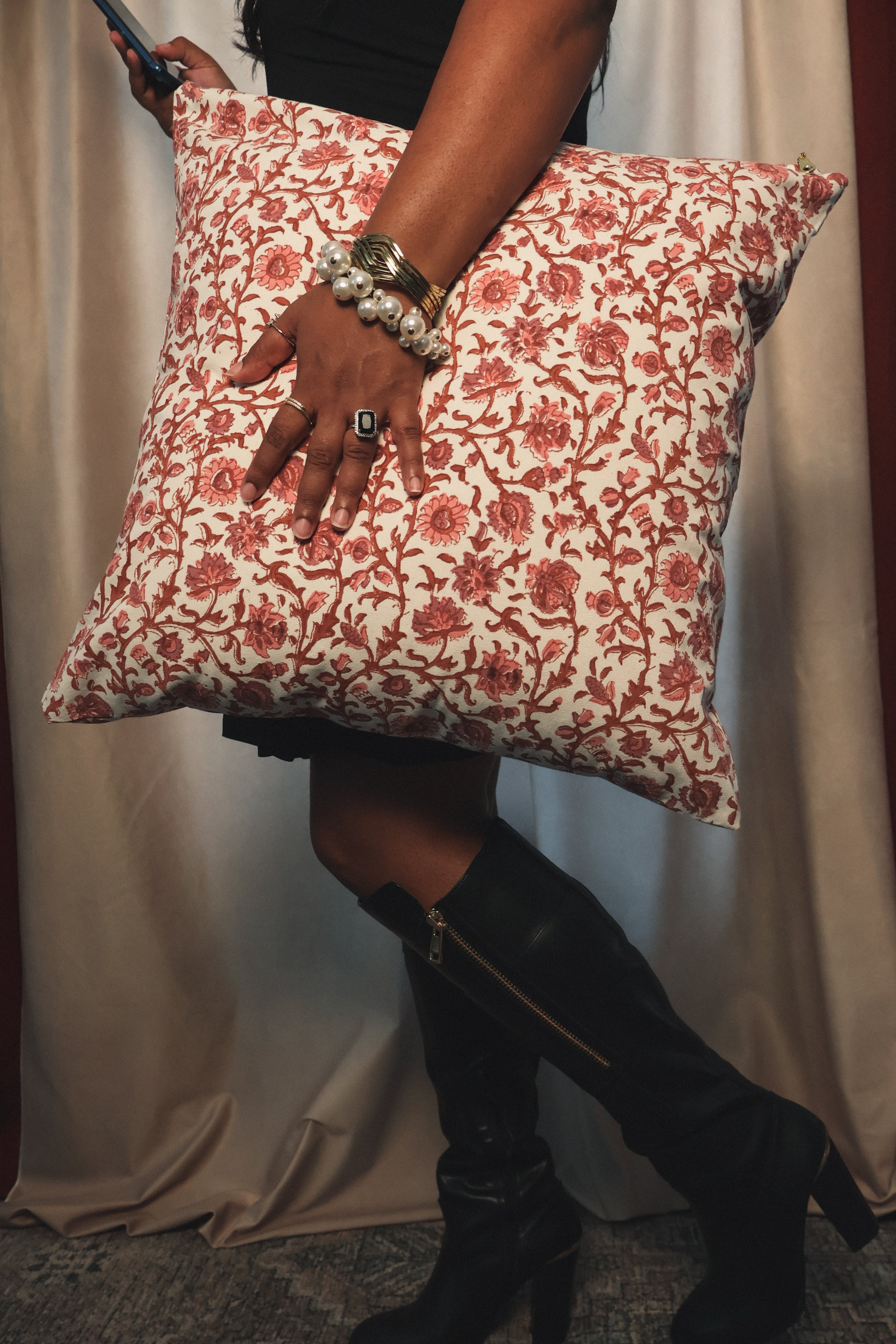 Person holding a floral pillow with a plain background